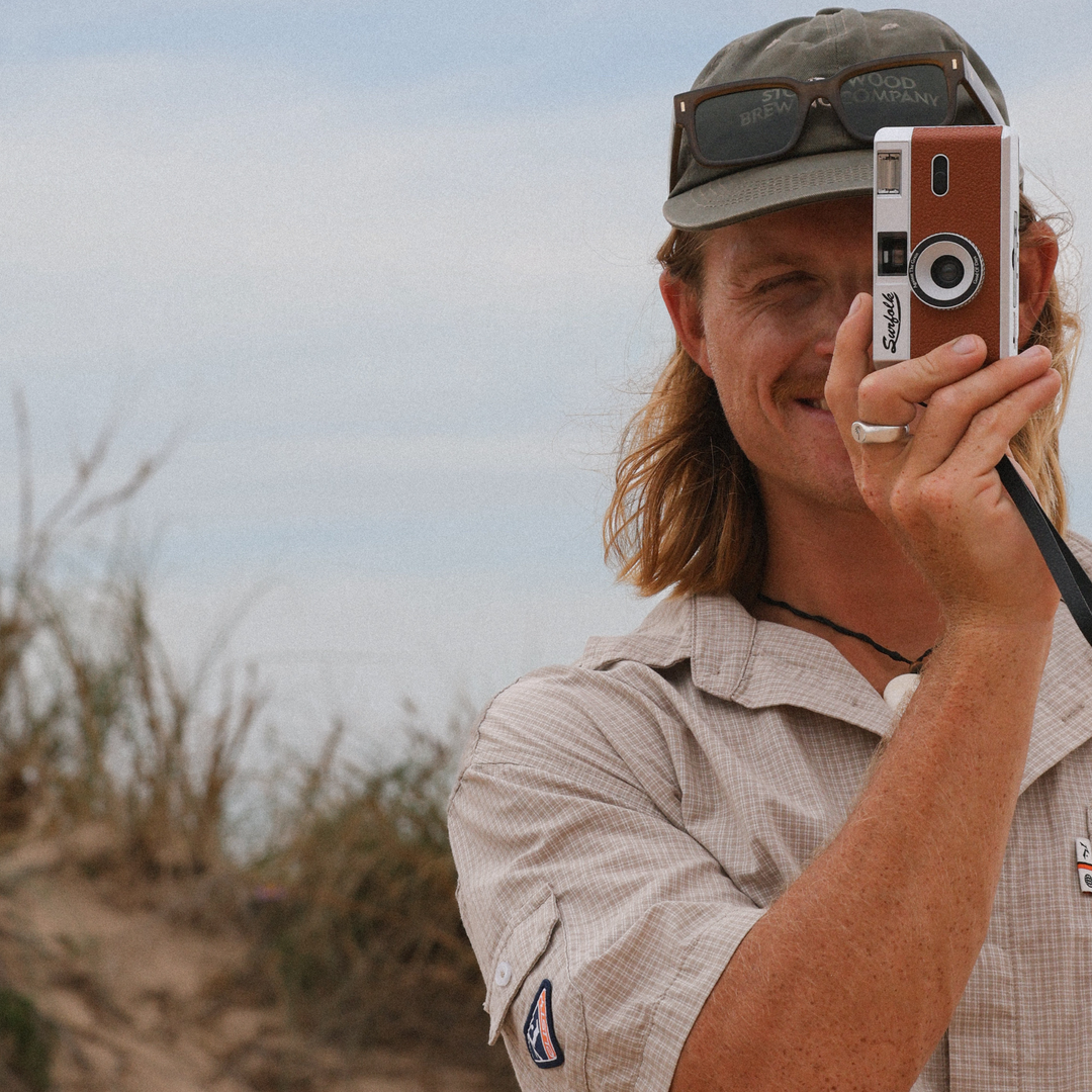 Man taking a photo with an old-fashioned camera outdoors n